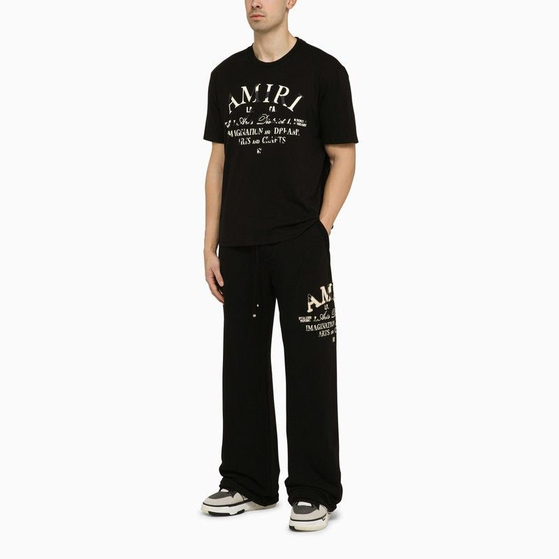 男士黑色棉質運動長褲，側邊印有品牌標誌和皮革標籤