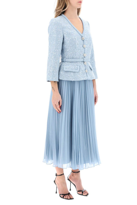 فستان ميدي بلون فاتح وتصميم مميز مع جزء علوي مطرّز بالزخارف الحريرية وحافّة مضفّرة